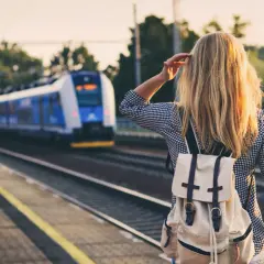 Dziewczyna z plecakiem czeka na pociąg, którym pojedzie nad morze.
