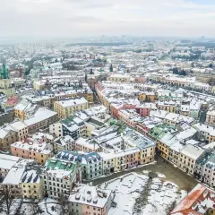 Zimowy krajobraz Lublina pokryty śniegiem. Idealne miejsce na ferie zimowe 2026 lubelskie, z kolorowymi kamienicami i zabytkowymi kościołami.