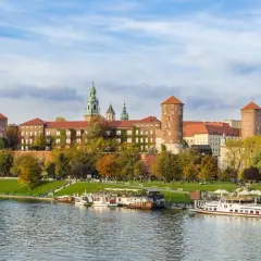 Zabytkowe miasto nad Wisłą, Wawel w jesiennej odsłonie. Statki wycieczkowe cumują przy brzegu.