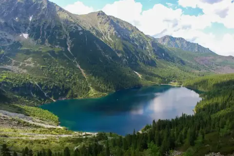 Malownicze Morskie Oko, idealne na górską trasę. Otoczone zielonymi lasami i skalistymi szczytami, zachwyca spokojną taflą wody.