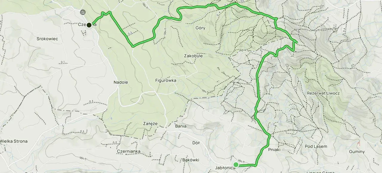 Mapa z zaznaczoną trasą turystyczną przez wzgórza i lasy, z nazwami miejscowości i rezerwatu.