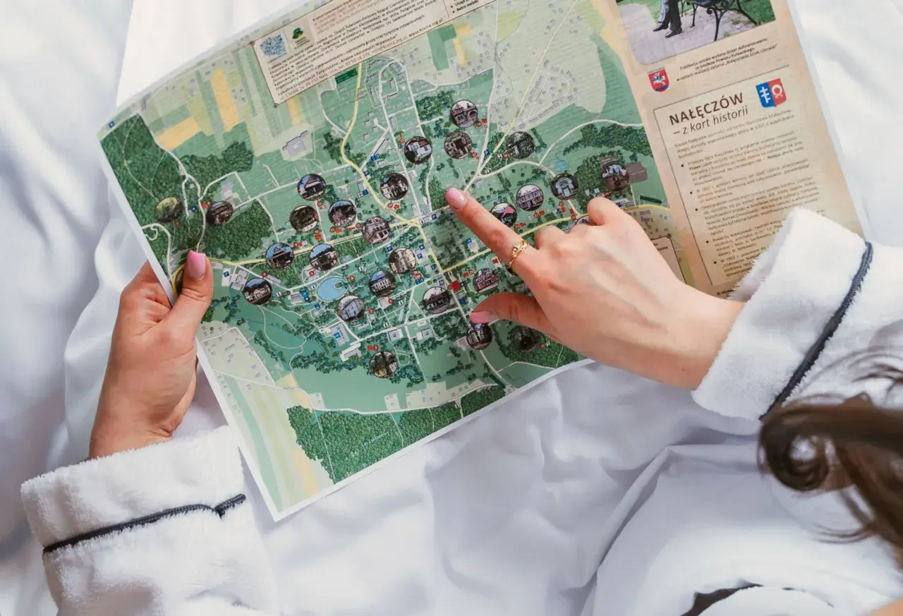 Ręka wskazuje na mapę Nałęczowa, planując, kiedy są wakacje i co zwiedzić.