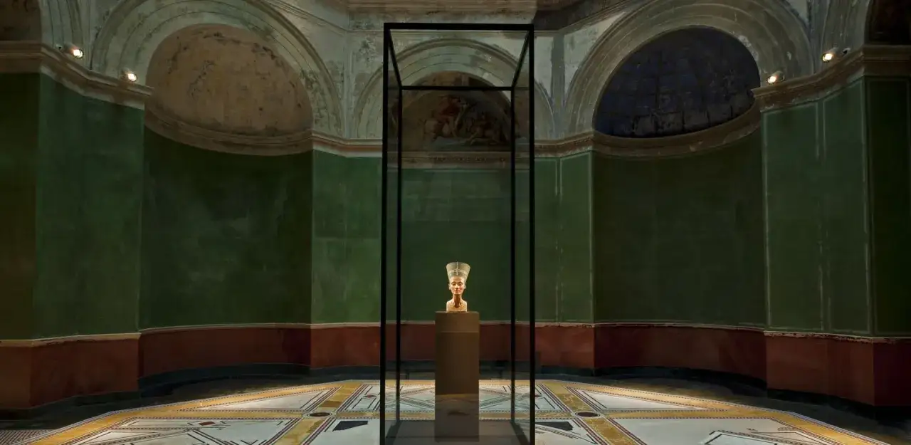 Popiersie Nefertiti w szklanej gablocie, w historycznej sali Neues Museum.