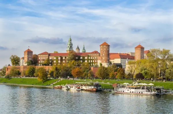 Zabytkowe miasto nad Wisłą, Wawel w jesiennej odsłonie. Statki wycieczkowe cumują przy brzegu.
